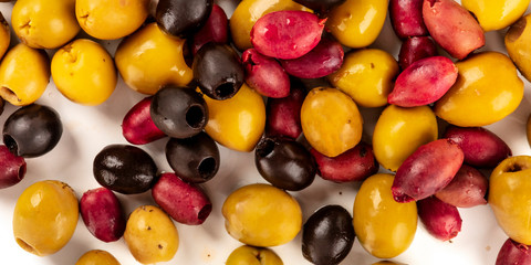 Olives overhead panorama. Green, black and red olives, shot from above on white