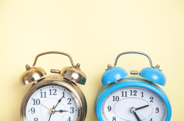 Alarm clocks on yellow background. Top view