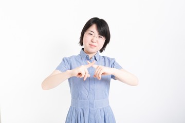 拒否のハンドサインをするワンピースを着た女性