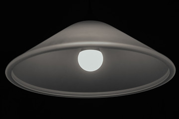 Chandelier with a lamp on a dark background.