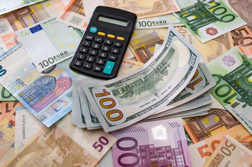 calculator on a background of euros and dollars. View from above. Business concept.