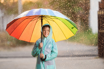 Asians, children spreading umbrellas playing in the rain, she is wearing rainwear.