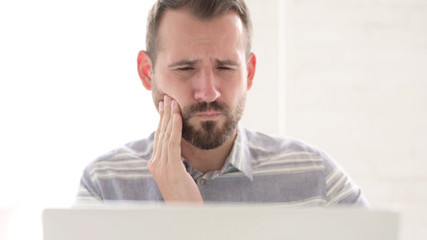 The Close Up of Man with Toothache Using Laptop