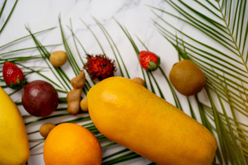 Exotic fruits and tropical palm leaves