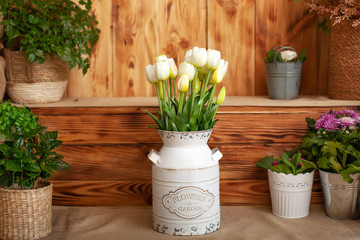 Bouquet White tulips flowers in a basket. interior of spring yard. Rustic terrace. Closeup of flower pots with plants. young plants growing in garden. Spring decoration, tulips in a basket. Easter