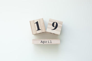 April 19 Easter Wooden block calendar on white isolated background. Easter. View from above with copy space. Christianity Easter. Rustic wooden decor home. Spring Easter Holiday Card. Top view. celebr