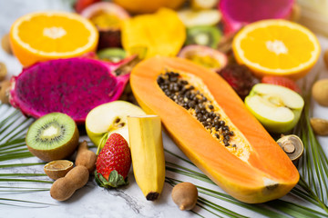 Exotic fruits and tropical leaves on table