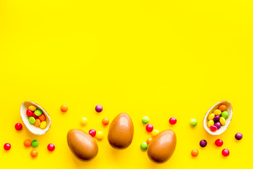 Chocolate eggs - Easter symbol - frame on yellow background top-down copy space