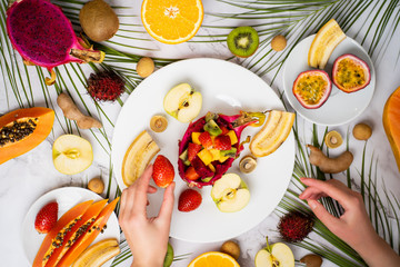 Exotic fruits and tropical leaves on table