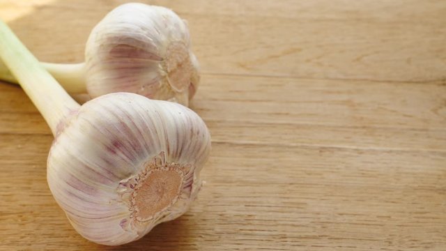 Two garlic bulbs on wooden rustic board. Healthy food. Place for text, copy space
