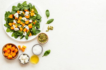 Cooking salad with pumpkin and basil. Ingredients on white background top-down copy space