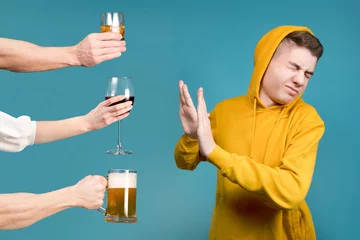 Poster Im Rahmen Teenager in einem gelben Sweatshirt lehnt verschiedene Arten von Alkohol ab © Вячеслав Думчев