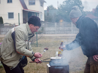 picnic men cook meat at the stake