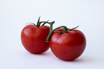 two juicy tomatoes on a white background