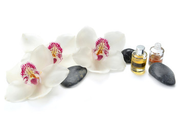 Fototapeta na wymiar oil bottles and pebbles with beautiful orchids on white background