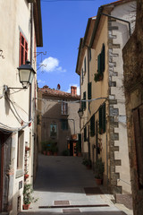 Fototapeta premium Scansano (GR), Italy - June 10, 2017: A central road and typical houses in Scansano, Grosseto, Tuscany, Italy