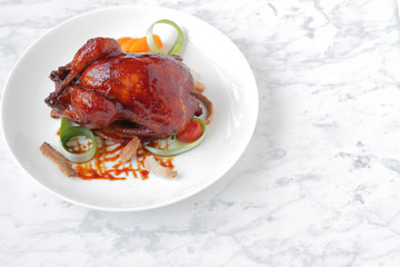  Baked, tasty juicy, quail with spices herbs and soy sauce, beautifully served on a marble table