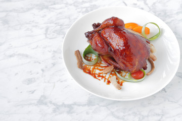  Baked, tasty juicy, quail with spices herbs and soy sauce, beautifully served on a marble table