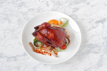  Baked, tasty juicy, quail with spices herbs and soy sauce, beautifully served on a marble table