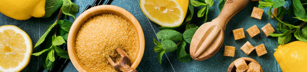 Concept with ingredients for homemade refreshing lemon juice lemonade, cane sugar, and mint on old...