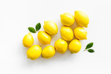Lemons backgrond - whole fruits with leaves - on white table top-down