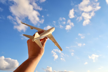 Travel and flight concept, airplane model in a man's hand. Travel photography motivator for vacation.
