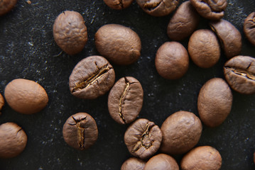 Coffee grains on dark background close up view