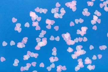 Confetti hearts on a blue background. Flat lay, copy space, top view. Holiday concept.