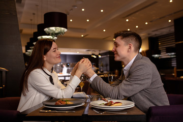 happy caucasian couple have dinner, dating in luxury restaurant. lady and guy enjoy spending time together. indoors