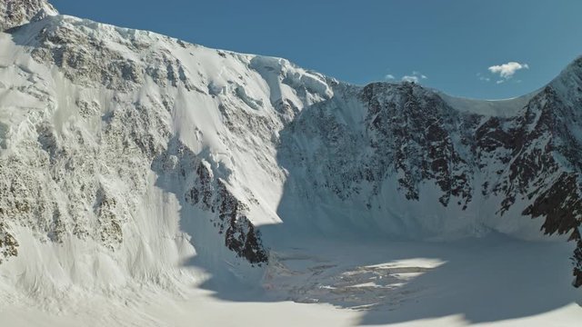 Scenic alpine panorama, snowy white iced Belukha mountain towering at blue sky 