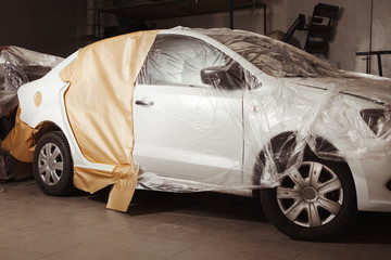 Garage painting car service. vehicle cover with protective paper before painting.