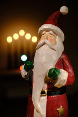 santa claus decoration in front of candle lights with room for copy