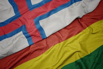 waving colorful flag of bolivia and national flag of faroe islands.