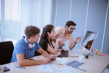 Fototapeta premium A Businessman and businesswoman looking at laptop computer and newspaper of work discussing for work diagram in office company with business meeting concept.