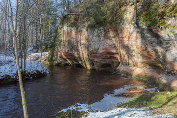 City Ligatne, Latvia. River in winter with sandstone cliffs and caves.