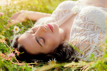 Portrait of pregnant woman relax at the nature field with chamomile flowers