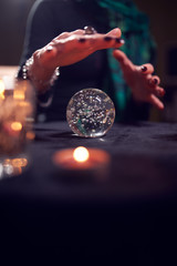 Close-up of female fortune-teller's hands with ball of predictions