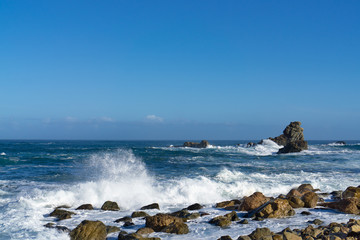 Fototapeta na wymiar The rough Atlantic Ocean near Tenerife, Spain, strong waves break on the rocks in the water