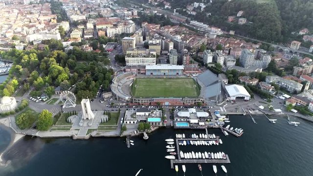 Helicopter aerial view of coastal area of Lake Como showing Tempio Voltiano and Monumento ai caduti on left and Stadio Giuseppe Sinigaglia in front urban part 4k high resolution quality footage