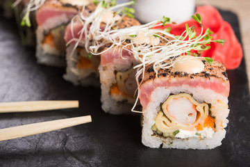 Closeup of sushi roll with salmon on a black slate background. japanese food menu