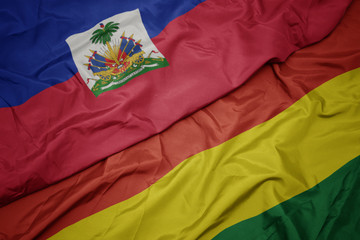 waving colorful flag of bolivia and national flag of haiti.
