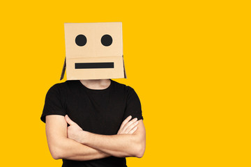 Portrait of an indifferent man with a box and cartoony emotions on his head. Unhappy people. - obrazy, fototapety, plakaty