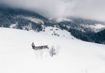 Winter landscape Romania sheepfold and barn in Sirnea Village at the foothills of the Carpathian Mountains