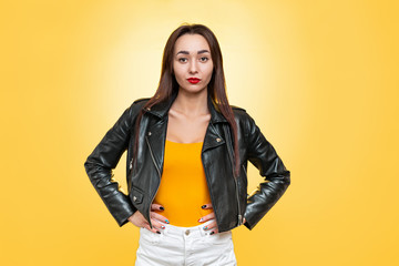 The concept of equality and feminism. An isolated shot of Caucasian woman in a leather jacket poses...