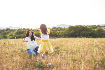 Fototapeta premium Active female child runs to the pregnant motheк on the meadow