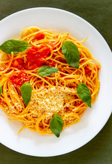 Pasta spaghetti with tomatoes, basil and parmesan cheese. Italian cuisine. Recipe. Vegetarian food. Healthy eating.