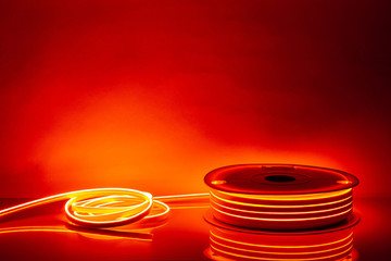 Flexible orange LED neon strip on black background