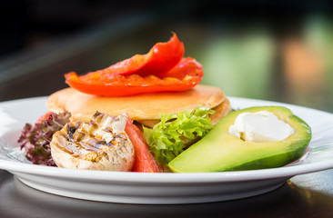 Vegetarian pancakes with grilled vegetables. Mushrooms, peppers and avocados. Decorated with grapefruit and salad