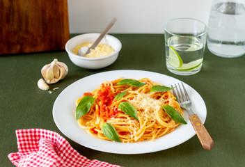 Pasta spaghetti with tomatoes, basil and parmesan cheese. Italian cuisine. Recipe. Vegetarian food. Healthy eating.