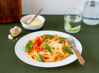 Pasta spaghetti with tomatoes, basil and parmesan cheese. Italian cuisine. Recipe. Vegetarian food. Healthy eating.